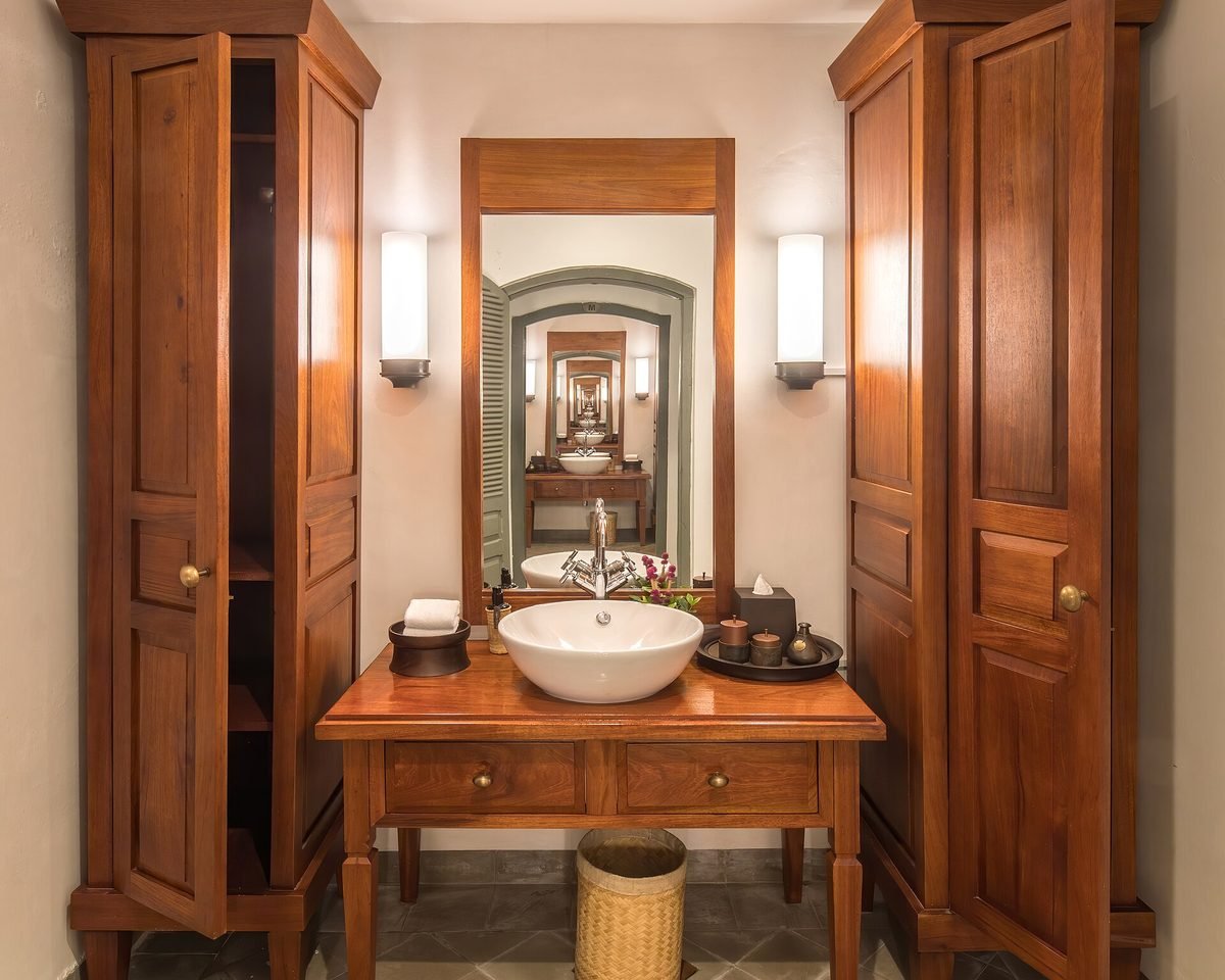 Hexagonal gold mirrors over a marble double vanity